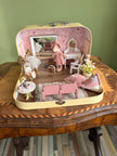 Front view of the Tiny Ballerina suitcase dollhouse with dance studio, vanity and pink theatre seats