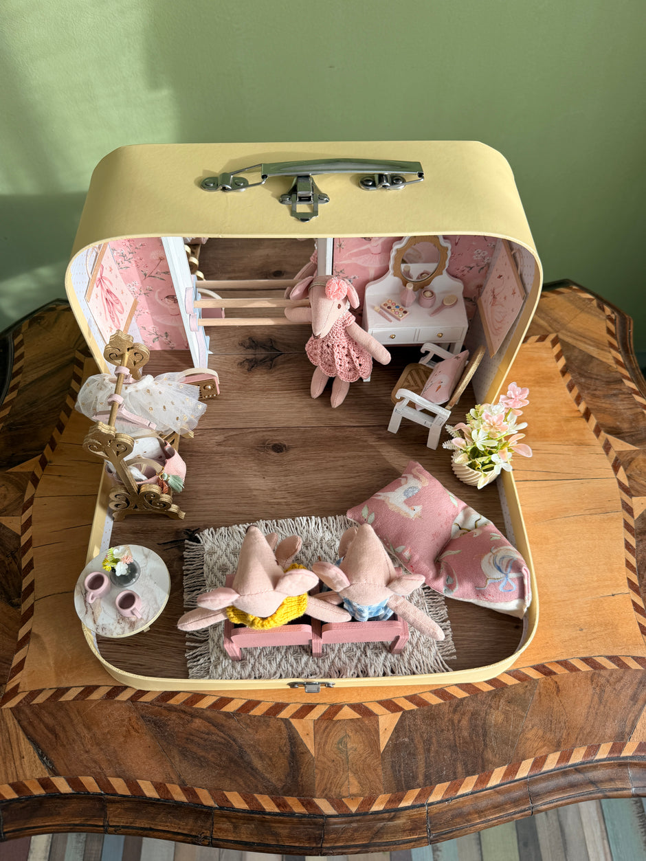Top view of the open ballerina suitcase dollhouse with ballet barre, vanity, rug, cushions and theatre seats