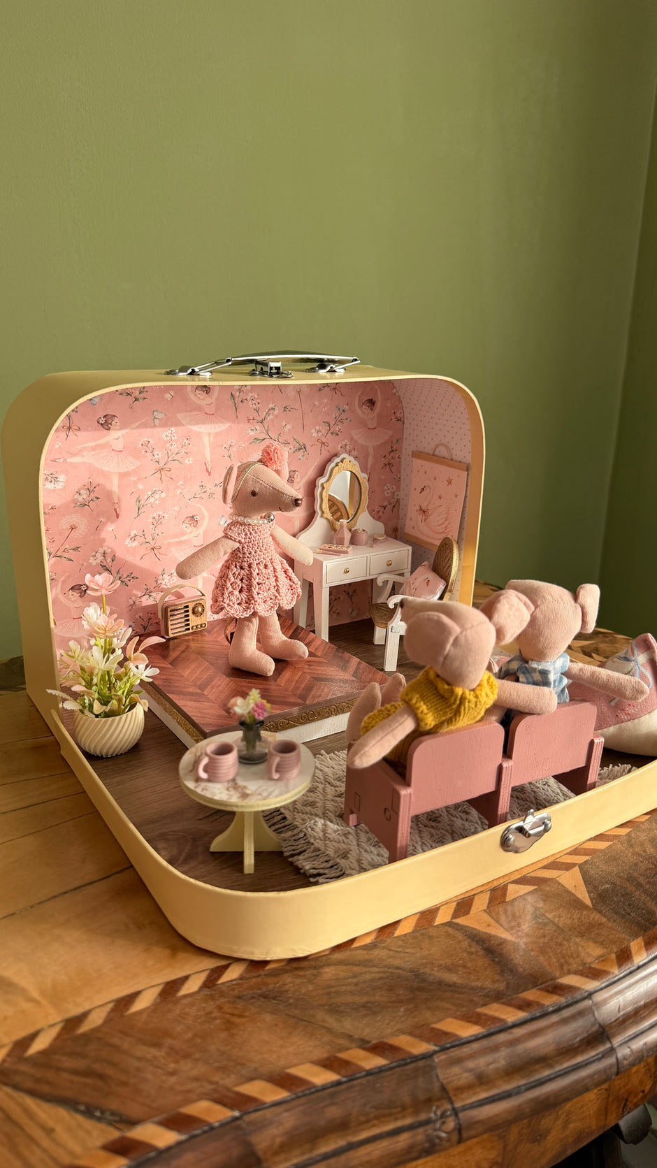 Two mouse friends in the front seats watching the ballerina mouse in the suitcase dollhouse