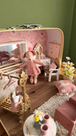 Ballerina mouse practising at the wooden ballet barre in front of the mirror inside the suitcase dollhouse