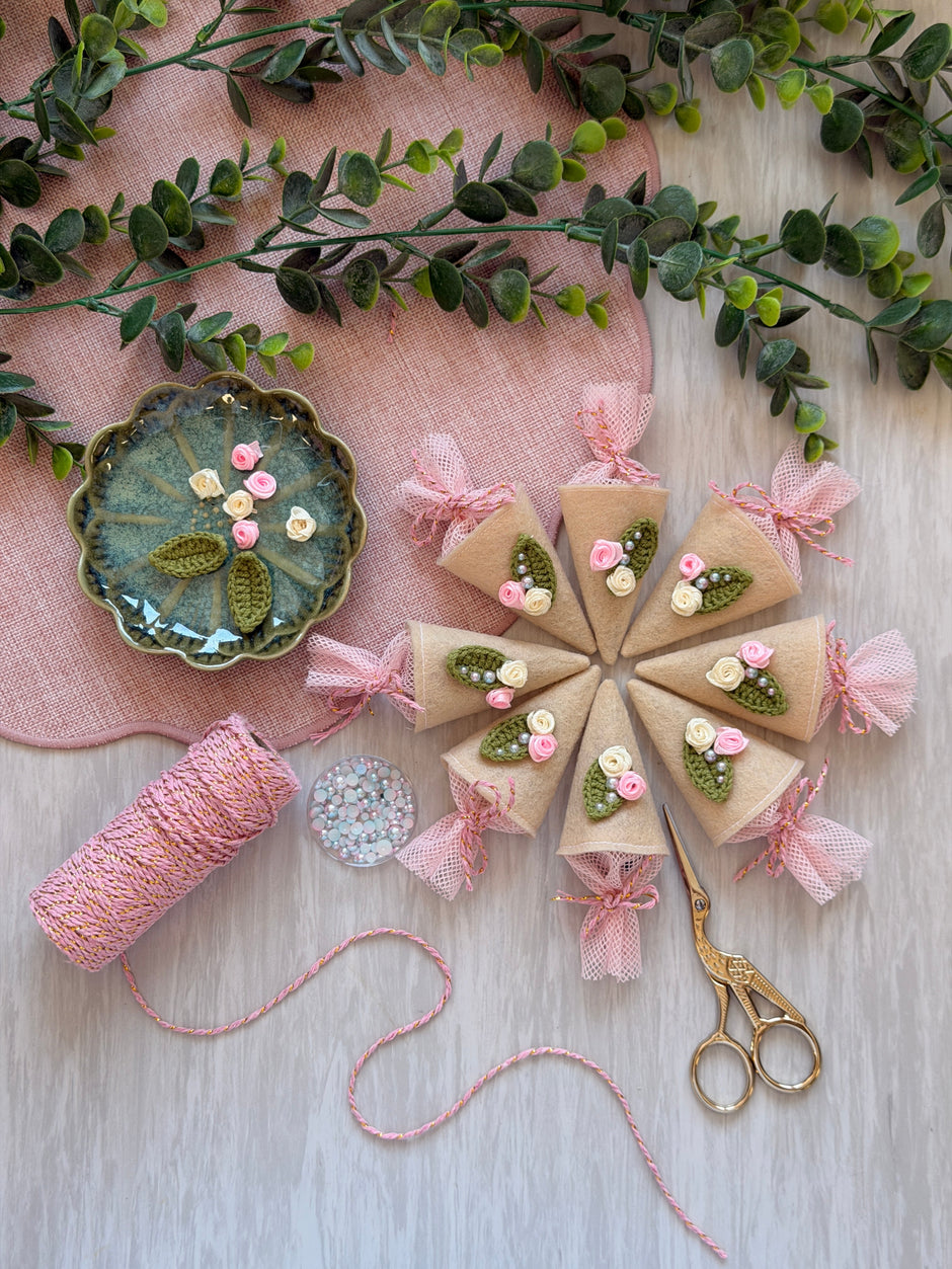 Handmade tiny felt Schultüte cones with crocheted rose trim, laid out flat
