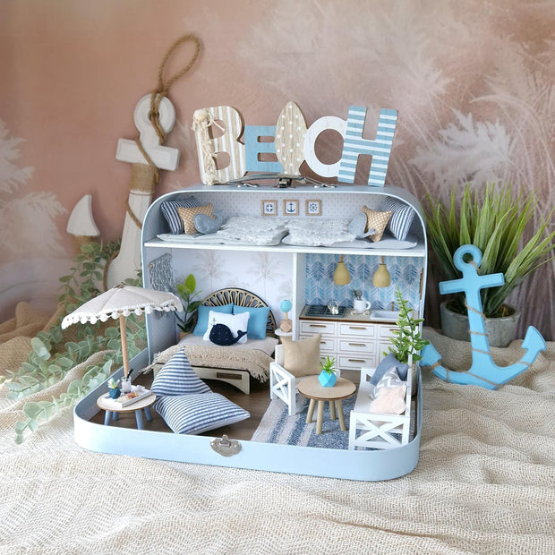 Coastal Breeze blue large suitcase dollhouse with a beach umbrella, striped floor cushions, white kitchen and loft