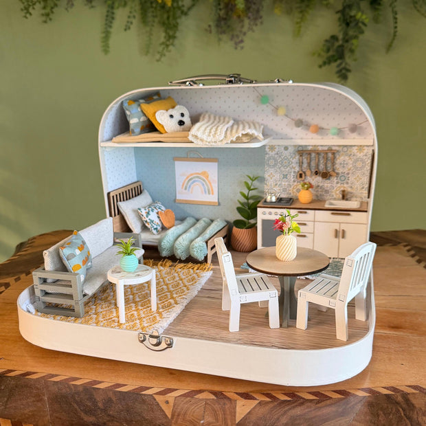 The Calm Grove medium suitcase dollhouse with grey sofa, round dining table, white kitchen and a loft with teddy bear