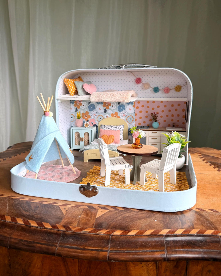 Happy Nest medium suitcase dollhouse with a play teepee, garland, round dining table and sleeping loft