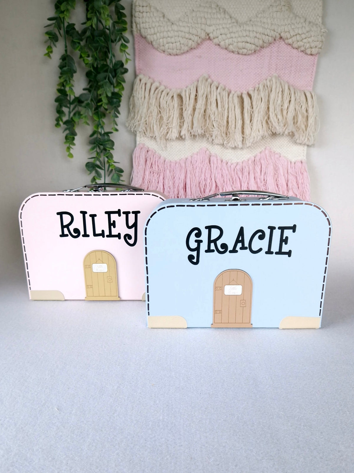Closed suitcase dollhouses from the outside, with a child's name above the little door